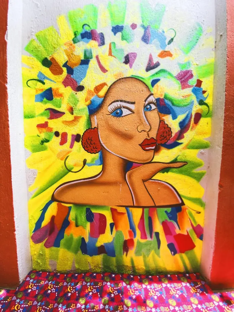Mural de una mujer con el pelo hecho de flores y colores