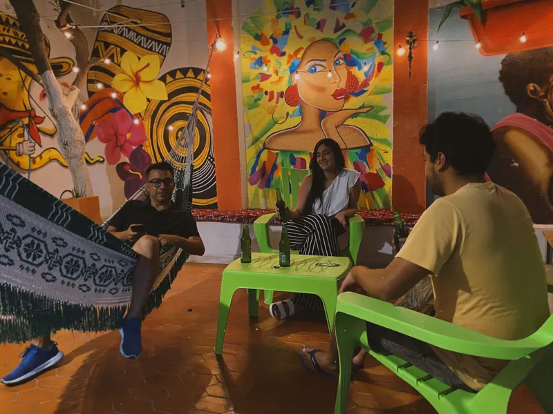 Huéspedes conversando en el patio de los murales