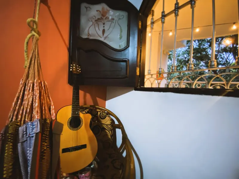 Rincón con una hamaca, una guitarra y una puerta de madera tallada